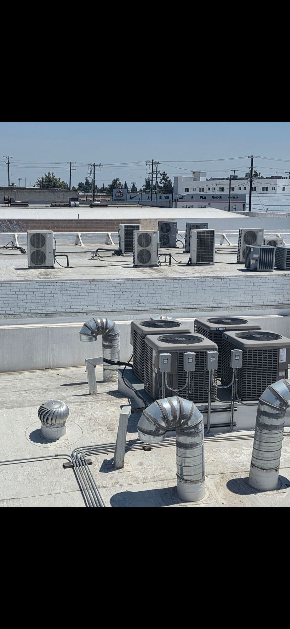 Air conditioning units and ventilation systems on a commercial building rooftop.