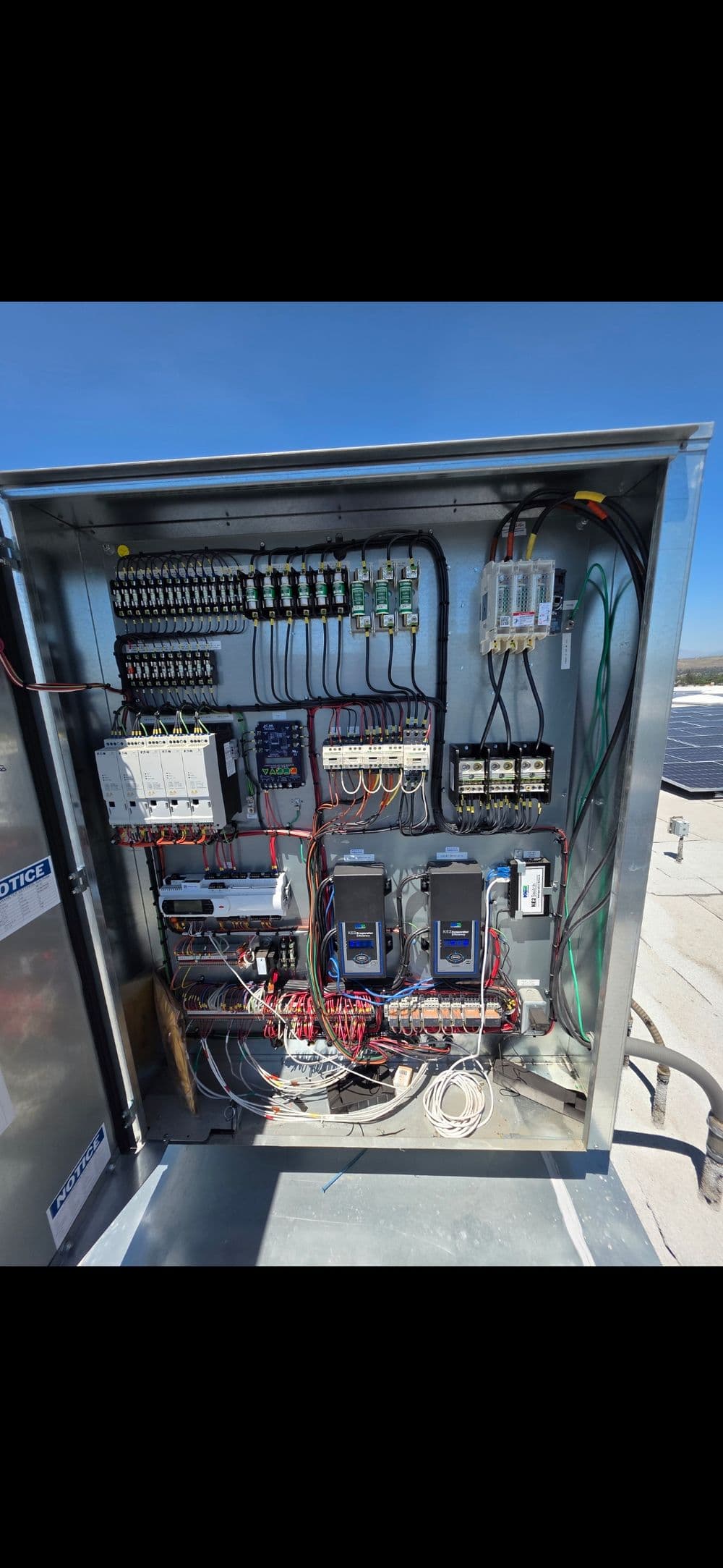 Electrical control panel with wiring and components for solar power system installation.