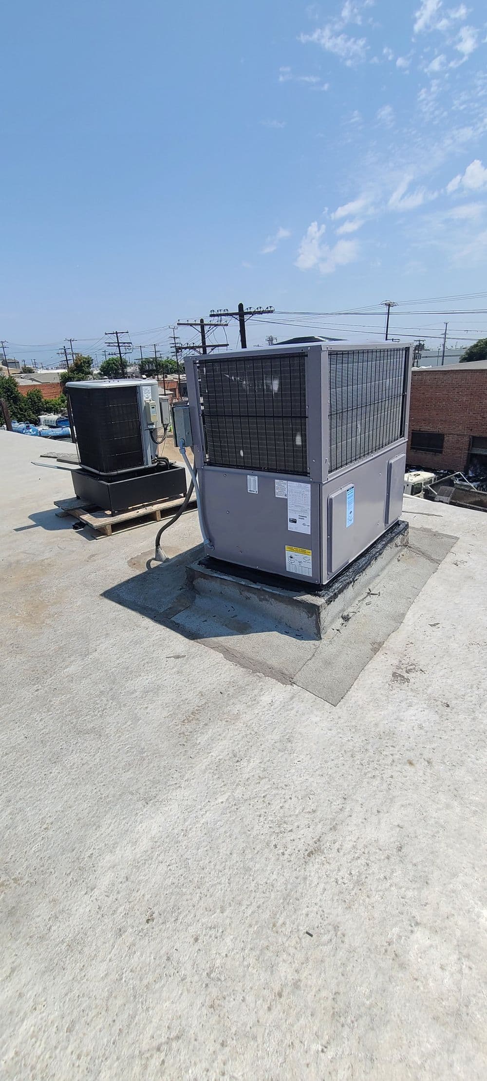 HVAC units installed on a commercial rooftop under a clear blue sky.