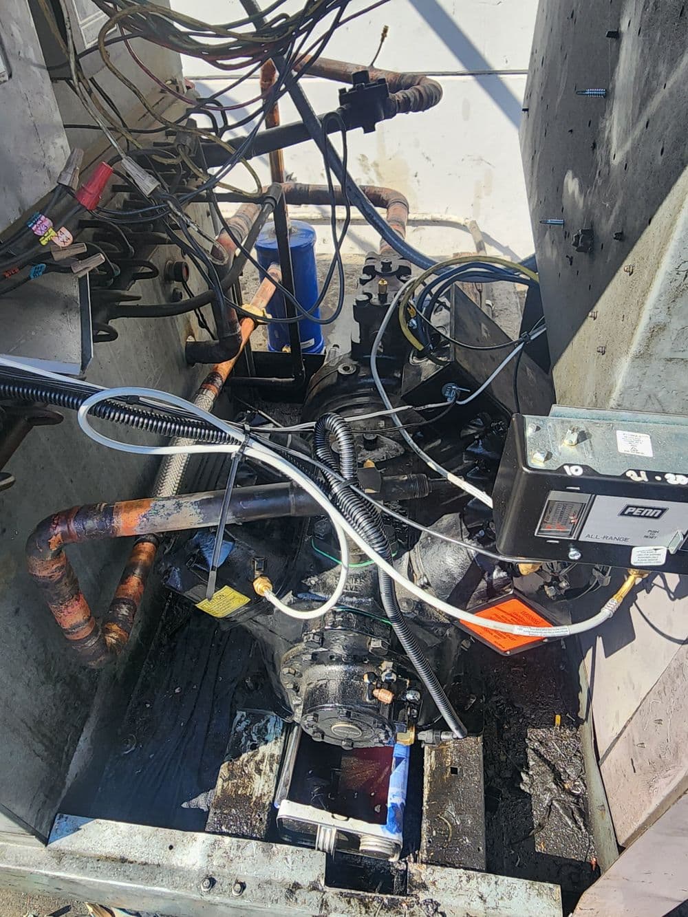 Mechanical equipment with exposed wires and pipes, showing oil leakage and machinery components.