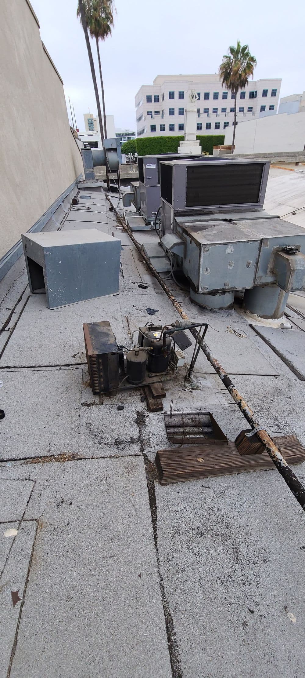 Roof equipment including HVAC units and power lines on a commercial building rooftop.