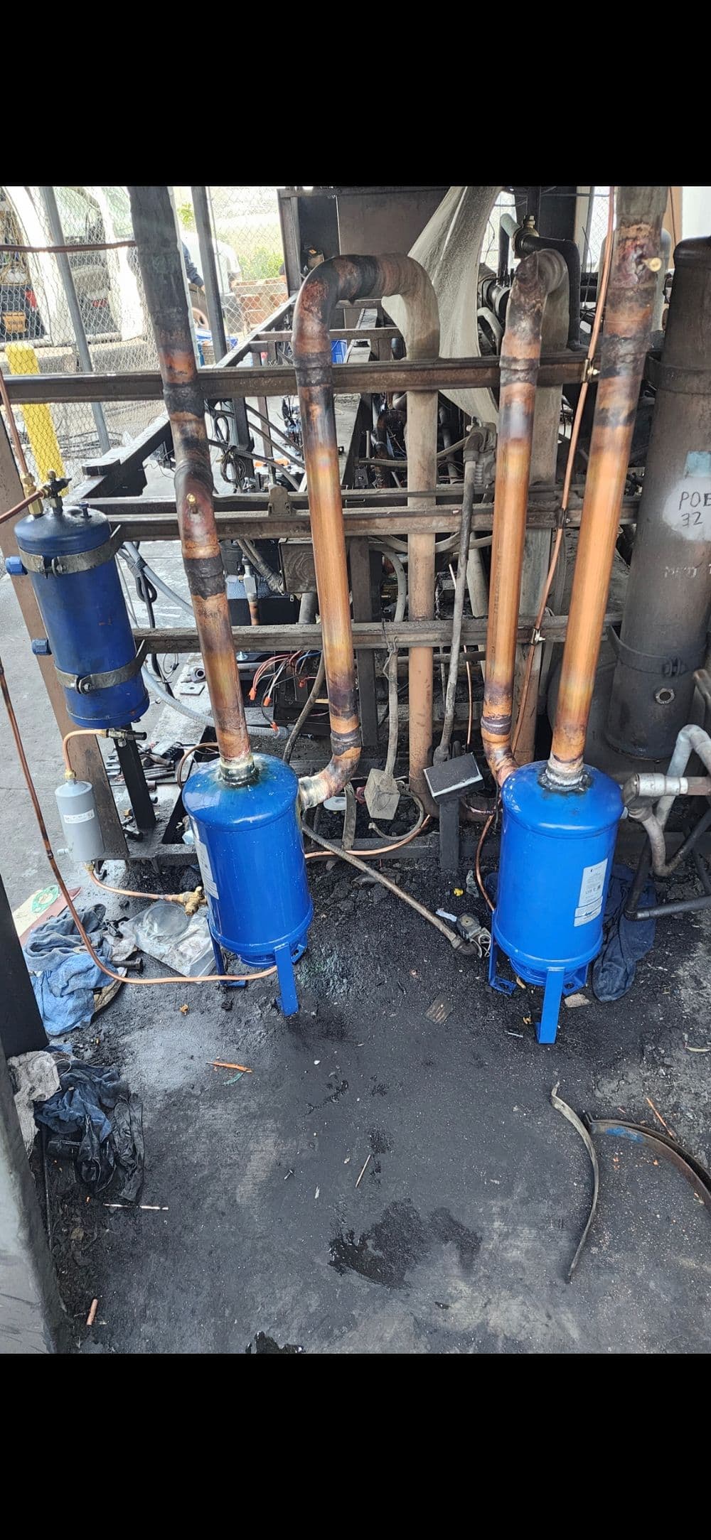 Industrial refrigeration system featuring blue compressors and copper piping.