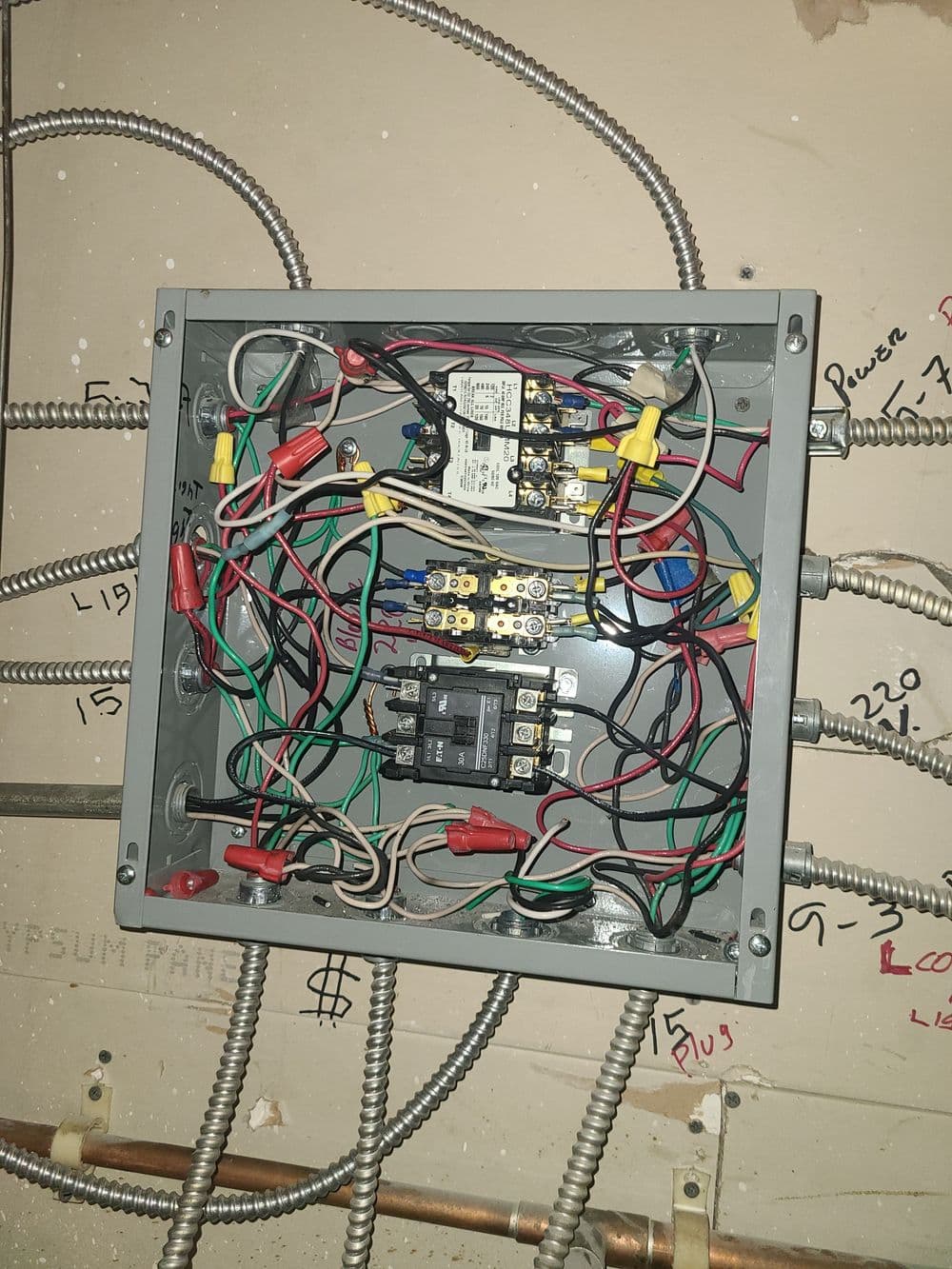 Electrical junction box with wires and terminals connected to circuit breakers.